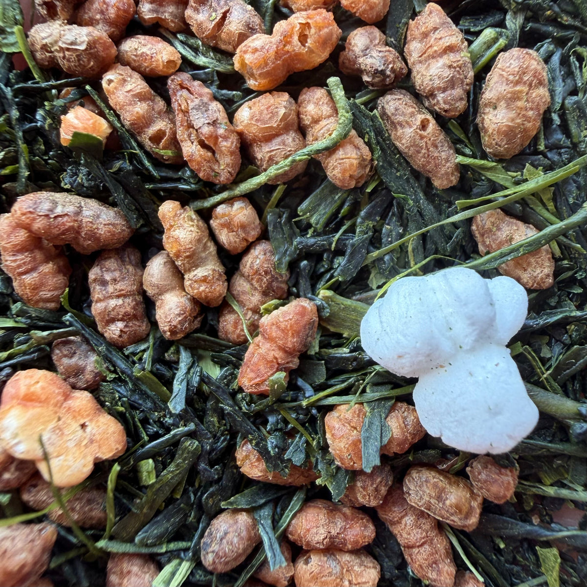 close up of genmaicha tea with an image of sencha tea leaves, puffed toasted rice