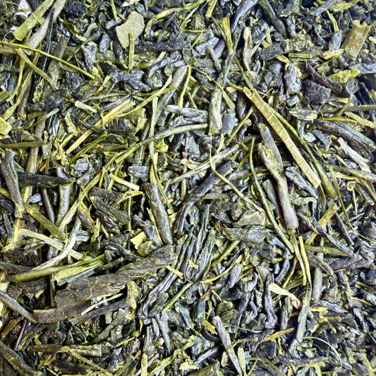 Close-up of loose-leaf tea leaves, showing dark green to olive green rolled leaves